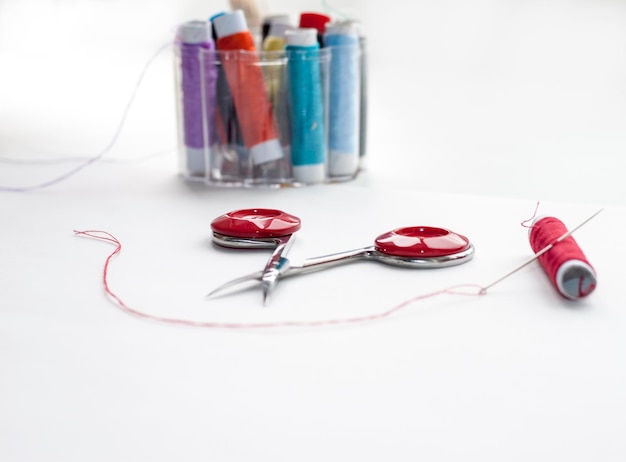 Нитки и игла рядом с готовой вышивкой